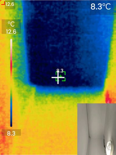 Thermal imaging showing a dark blue rectangular cold spot (8.3°C) on a wall, indicating an uninsulated structural concrete column creating a thermal bridge.