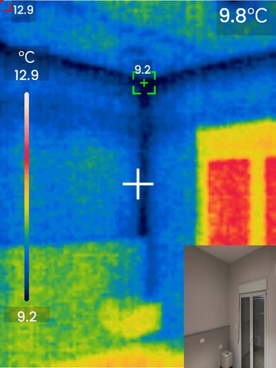 Thermal camera scan of a ceiling corner showing a blue Y-shaped cold pattern (8.6°C), indicating missing insulation and thermal bridging in the building structure.