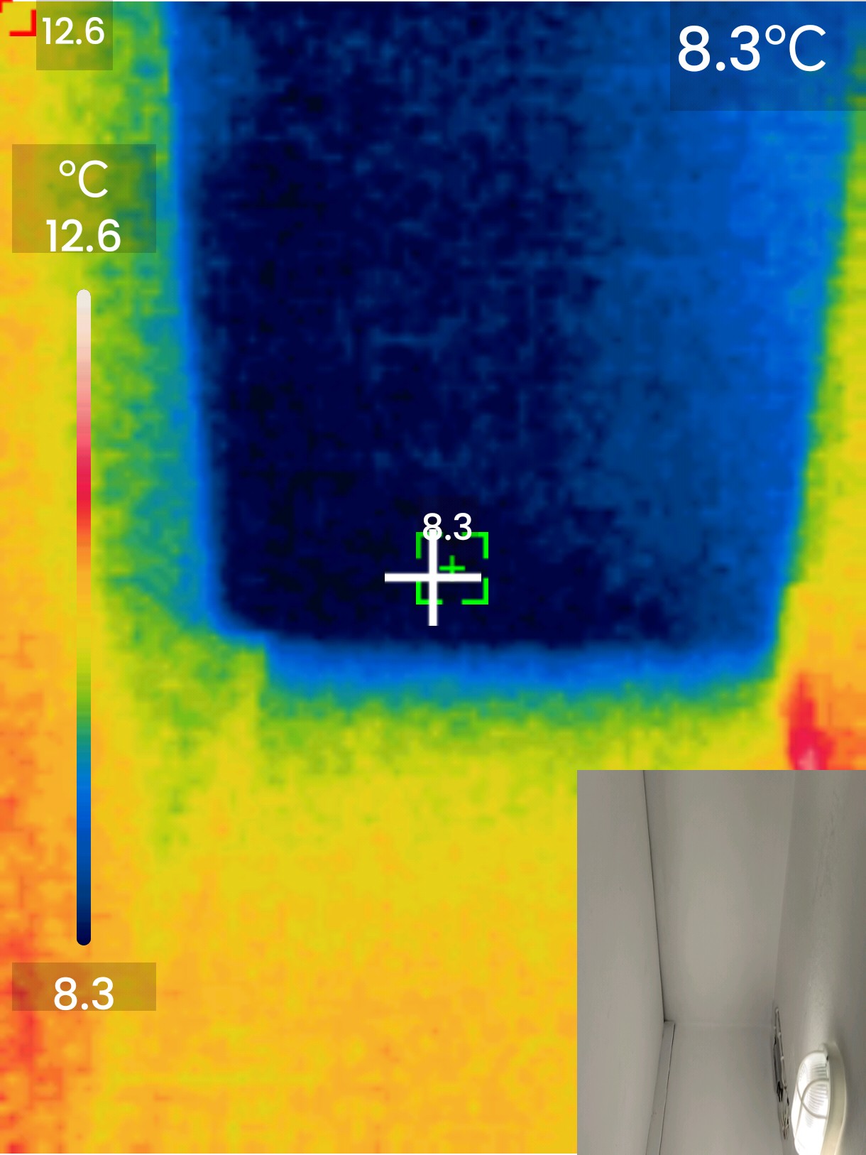 The Ghost in the Wall. To the naked eye, this is a smooth, white painted wall. To the thermal camera, a massive rectangular cold spot appears (indicated by the deep blue). This is a concrete structural column that has zero insulation. Thermal imaging showing a dark blue rectangular cold spot (8.3°C) on a wall, indicating an uninsulated structural concrete column creating a thermal bridge.